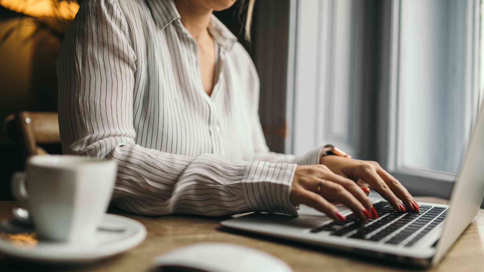 A business owner sitting at her desk, intently working on her laptop, figuring out how to outsource VA services