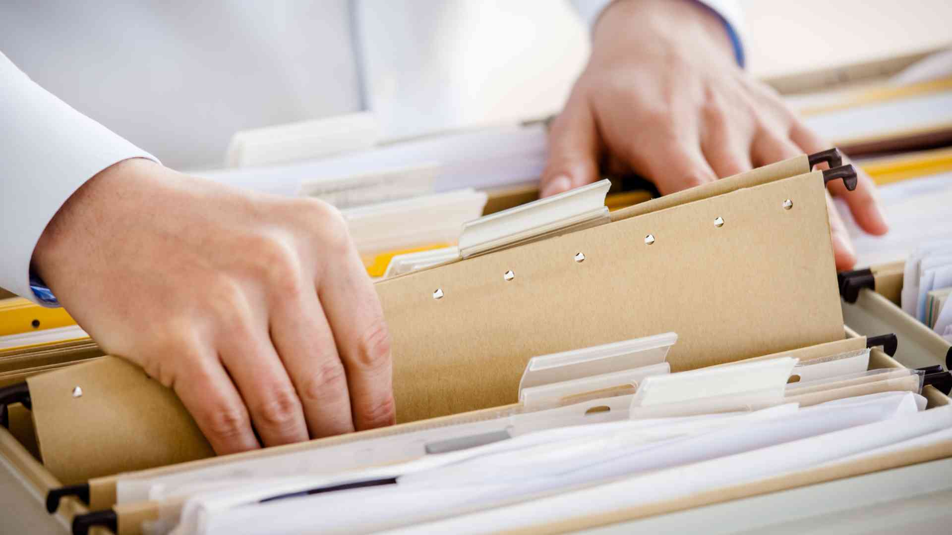 Organizing and filing documents into a labeled filing cabinet.