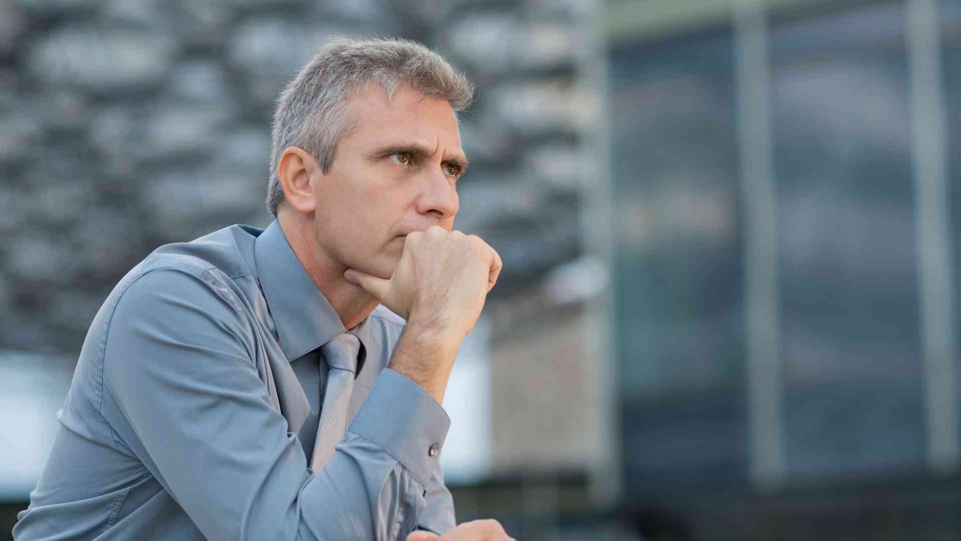 business owner in deep thought about which he should choose between a full time or a part time virtual assistant.