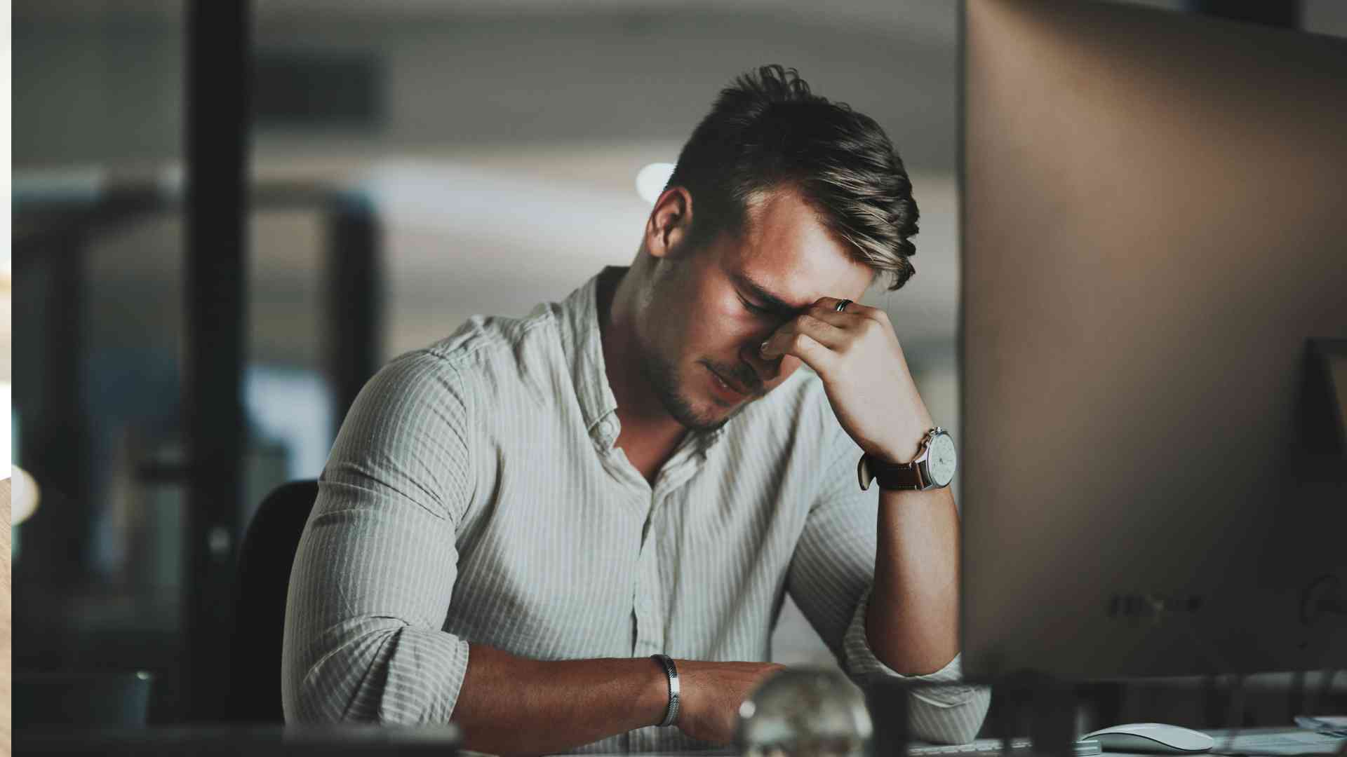 Stressed man at his desk, highlighting the challenges of managing data accuracy.